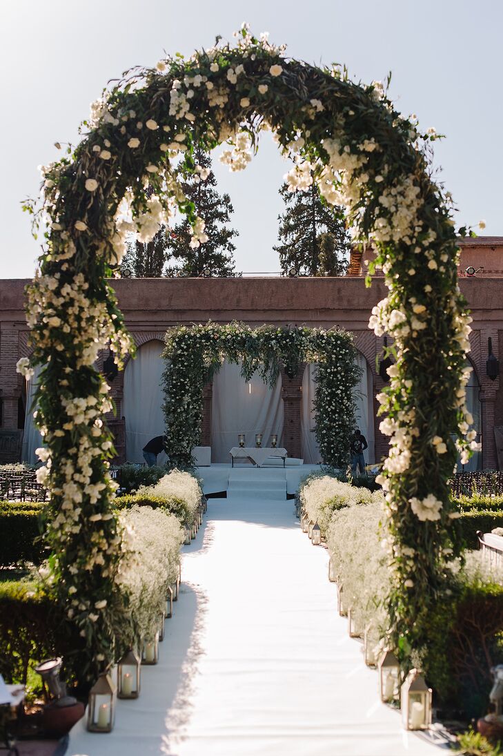 A floral archway and altar were constructed to add drama to the intimate space, and the aisle was lined with hedgerows of baby’s breath punctuated with silver lanterns.