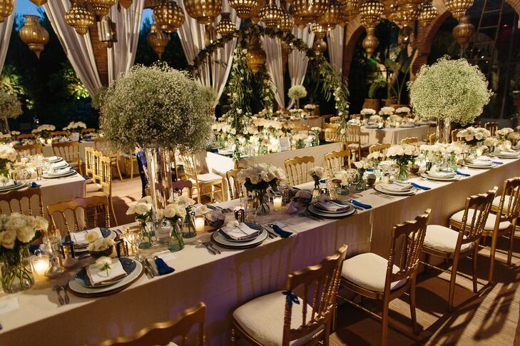 Fresh bundles of baby’s breath piled high atop hurricane vases and full white roses displayed in blue and white ceramic bowls worked with the reception’s lantern canopy and votive candles to achieve a whimsical, midsummer night feel. “The venue was adjacent to a stunning rose garden, and we wanted to give guests the sense that the roses were freshly picked from the garden for our wedding,” Lauren says.