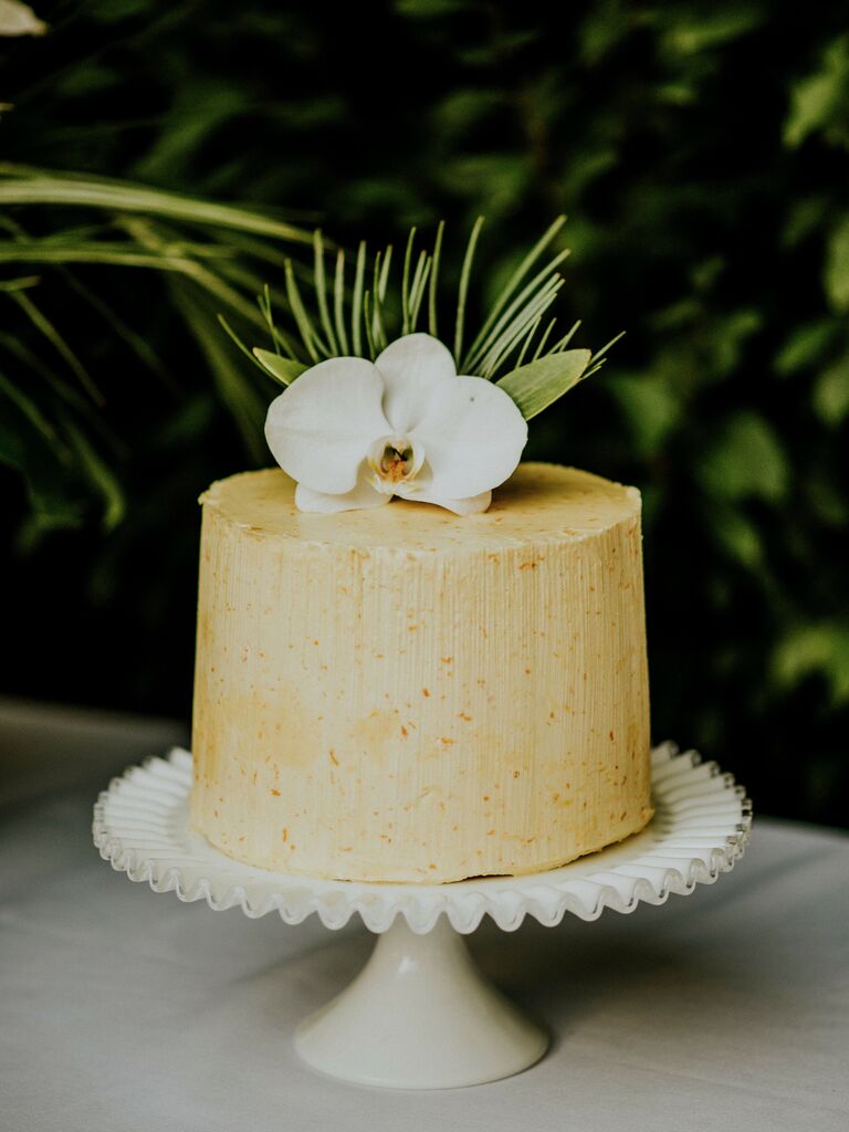 tropical one tier wedding cake with yellow frosting and white orchid on top
