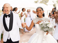 A bride and groom celebrate as they walk down the aisle.