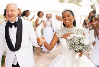 A bride and groom celebrate as they walk down the aisle.