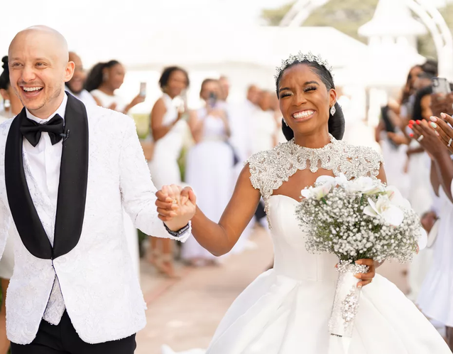 A bride and groom celebrate as they walk down the aisle.