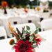Every arrangement on Shelby and Zack's tablescapes was a little different. 2Birds Events  filled the low gold and tall plum vases with a mix of red, green and burgundy hues to make it feel even more like fall. A specific centerpiece had red dahlias, eucalyptus, scabiosa and leaves.