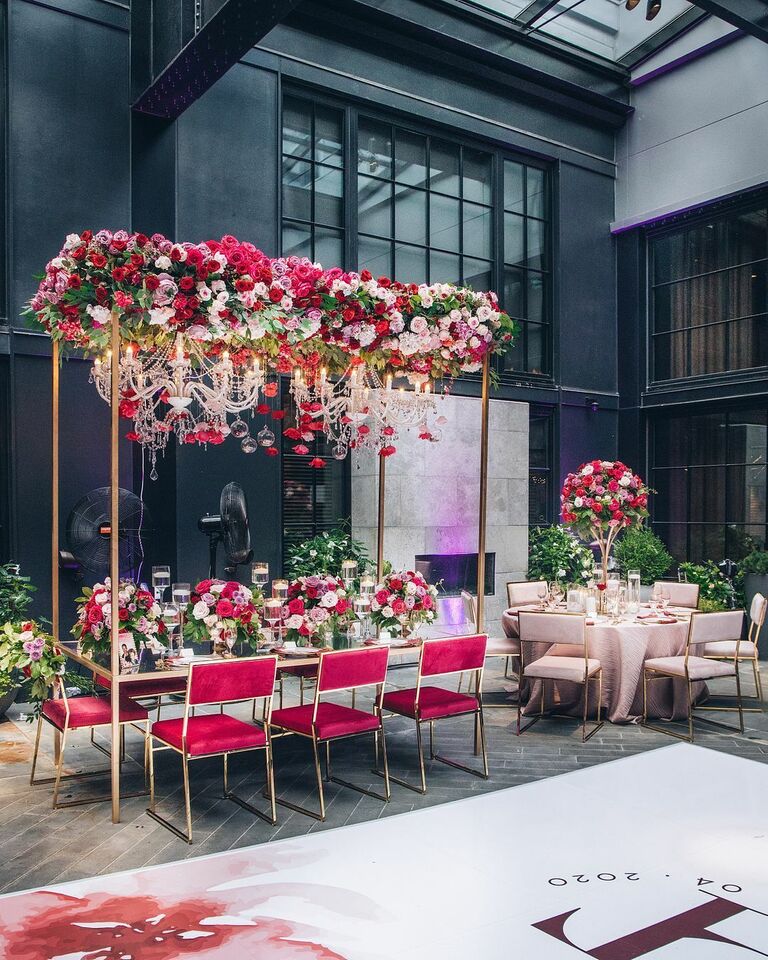 Glam red-and-pink reception with crystal chandeliers and rose decorations