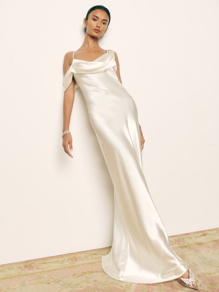 Model wears a silk Reformation white dress. 
