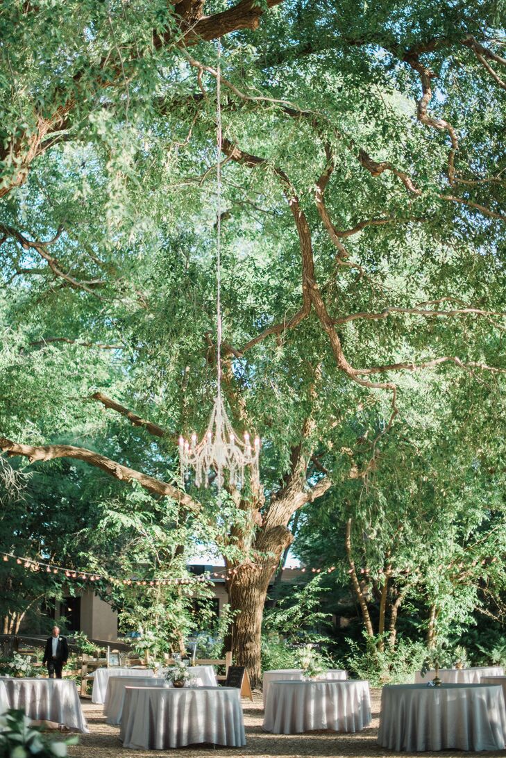 Spirit Ranch's outdoors were illuminated with romantic bistro lighting, and a beautiful chandelier hung from tree branches. “I wanted the feel of my wedding to be a touch vintage and a touch rustic,” Michelle says. “I wanted the design to feel like the items that were used could be family heirlooms or found along the way."