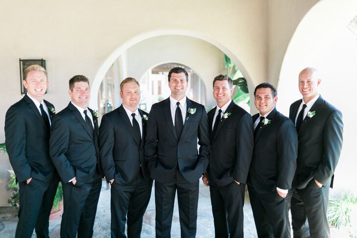 Greg and his six groomsmen wore traditional black suits with polished black loafers and crisp white shirts. They also wore delicate white rosette boutonnieres.