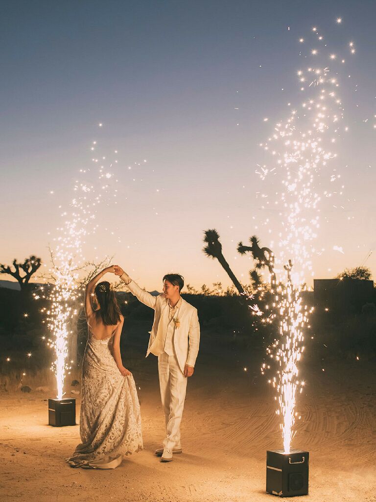 Bride and groom dancing in between sparkler displays