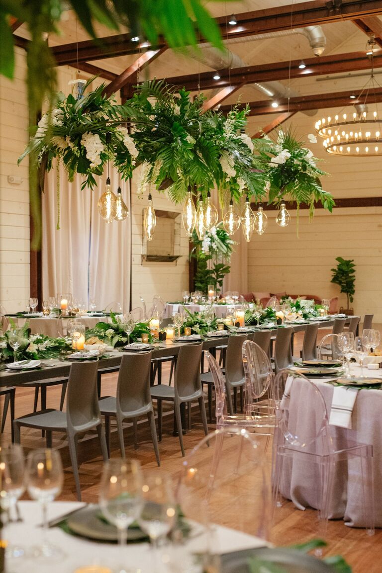 Tropical wedding reception with greenery chandelier