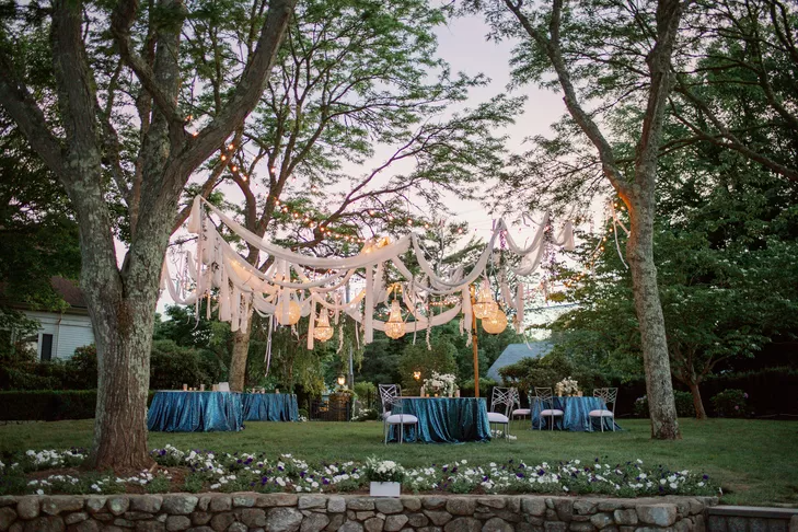 Outdoor wedding reception with fabric draping among the trees