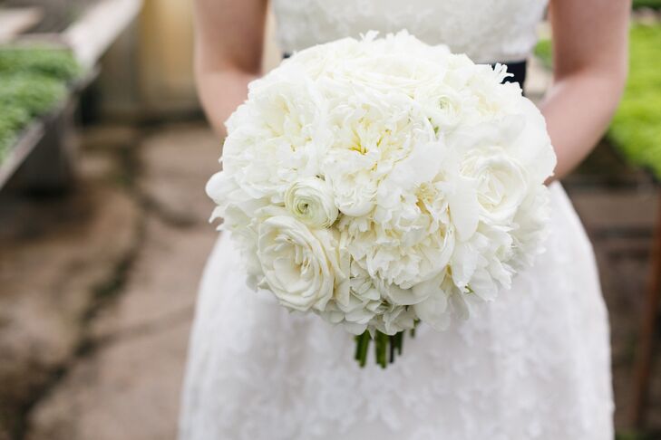 The bride carried a lush bouquet of all-white peonies, roses and ranunculuses.