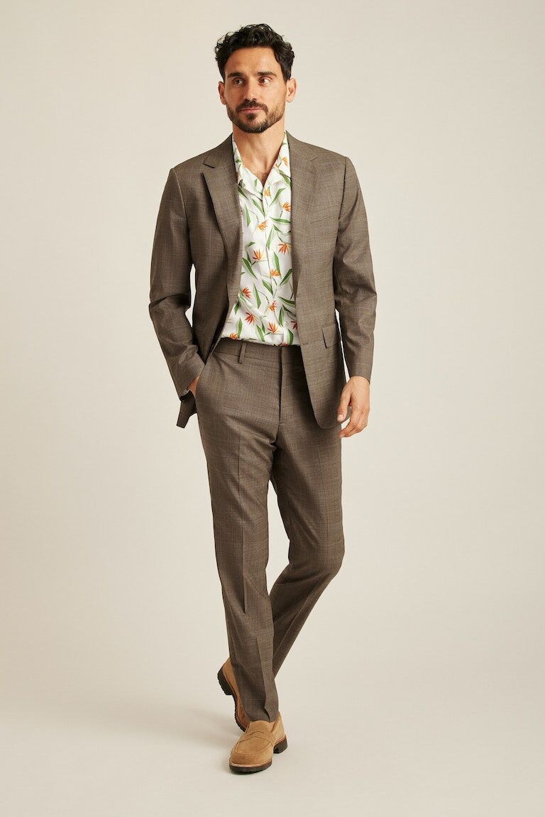 Neural colored suit with a patterned shirt underneath.