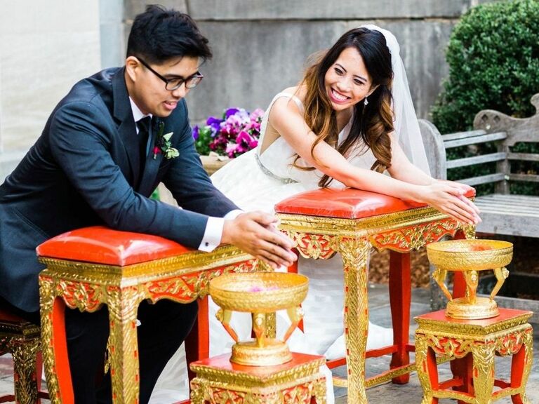 Couple smiling at each other during traditional Thai water blessing ceremony
