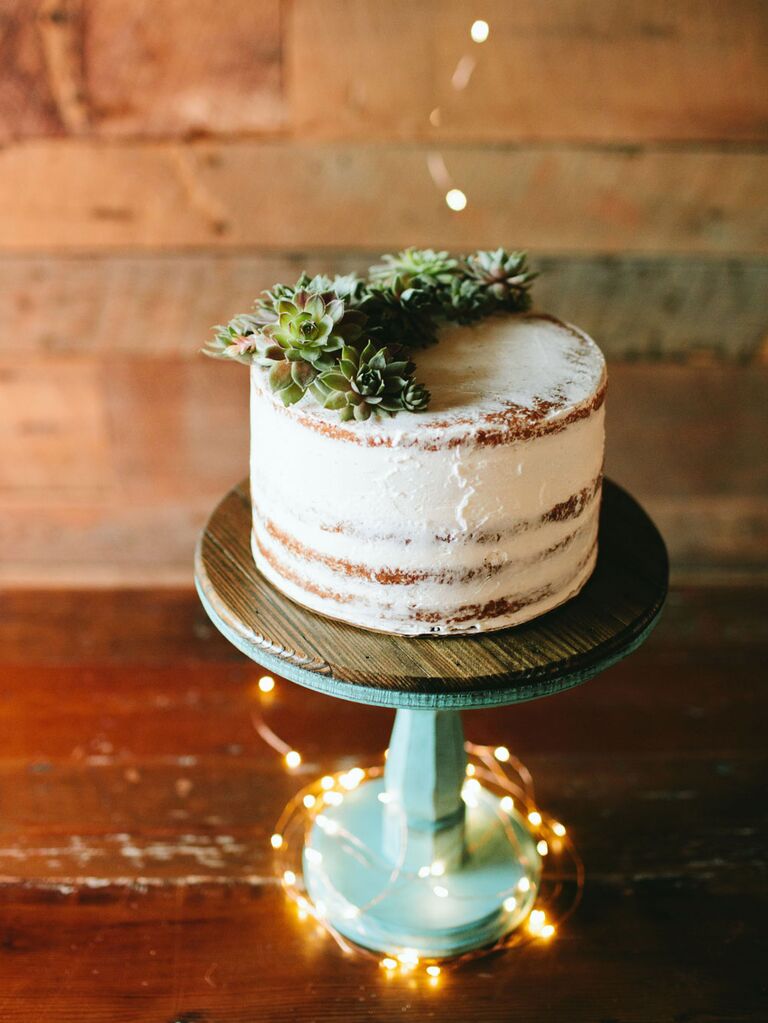 Single-tier semi-naked rustic cutting cake with fairy lights twisted around cake stand