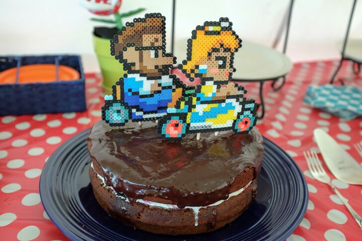 Jacob handmade the perler Mario Kart topper of the couple racing across the chocolate frosted chocolate cake.