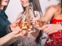 Bridesmaids and bride clinking champagne glasses at bachelorette party