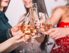 Bridesmaids and bride clinking champagne glasses at bachelorette party