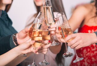 Bridesmaids and bride clinking champagne glasses at bachelorette party