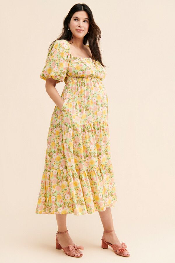Model wears yellow floral print dress with puffed sleeves. 