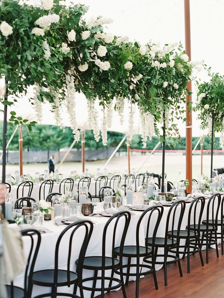 classic wedding tablescape with hanging greenery and white flower centerpiece above long table