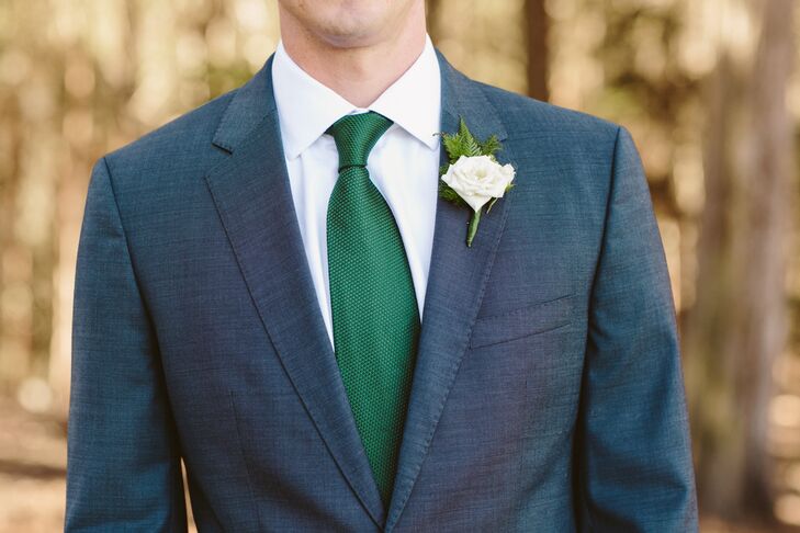 Pat wore a charcoal gray suit designed by Hugo Boss on the wedding day, complemented by an emerald green tie over his white-collared dress shirt. A single ivory rose was pinned to his suit jacket. All his groomsmen wore the same exact combination: a charcoal gray suit with an emerald green tie.