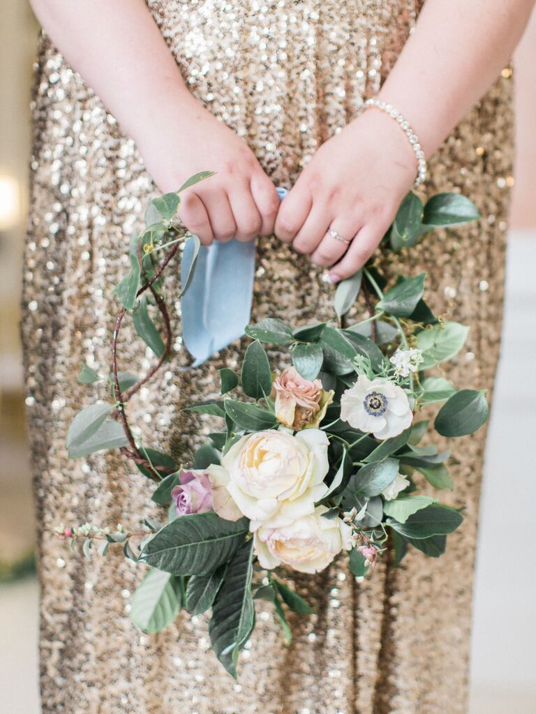 A bridesmaid holds a circular floral bouquet.