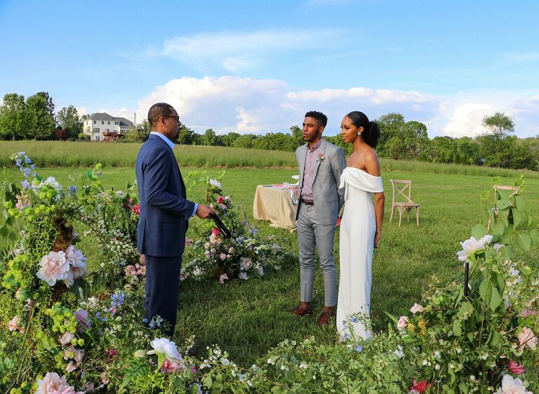 Couple exchanging vows in the middle of a field of flowers