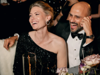 Woman wearing long sleeve one shoulder black sequined wedding guest dress