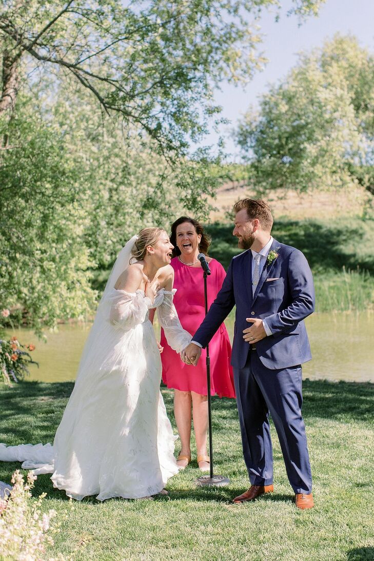 Couple at Outdoor Altar Laugh and Hold Hands in Front of Officiant