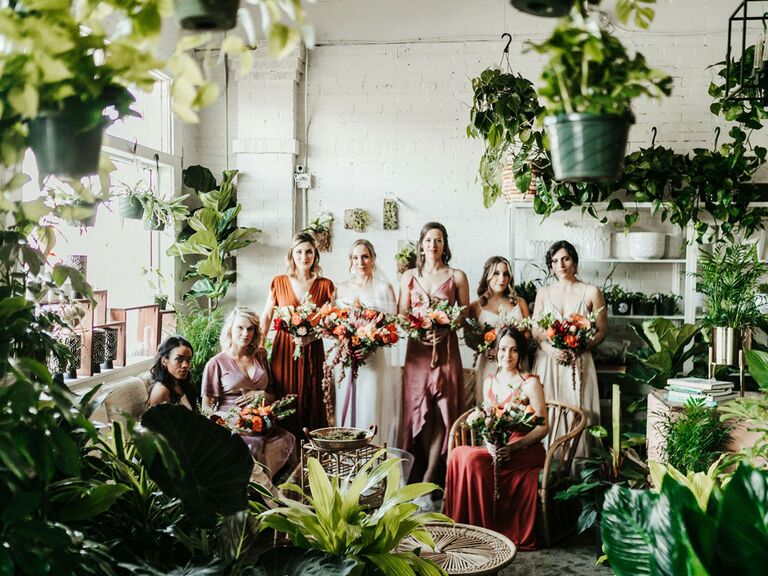 Bridesmaids posing in tree nursery with bride