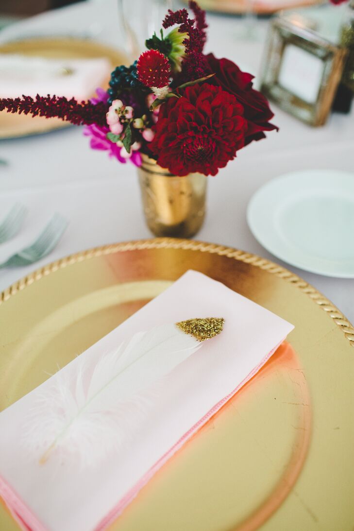 White feathers, dipped in gold glitter, were tucked into the napkins that rested atop gold chargers.