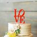 Two-Tiered Wedding Cake with Comb Frosting, Flowers and Red Cake Topper