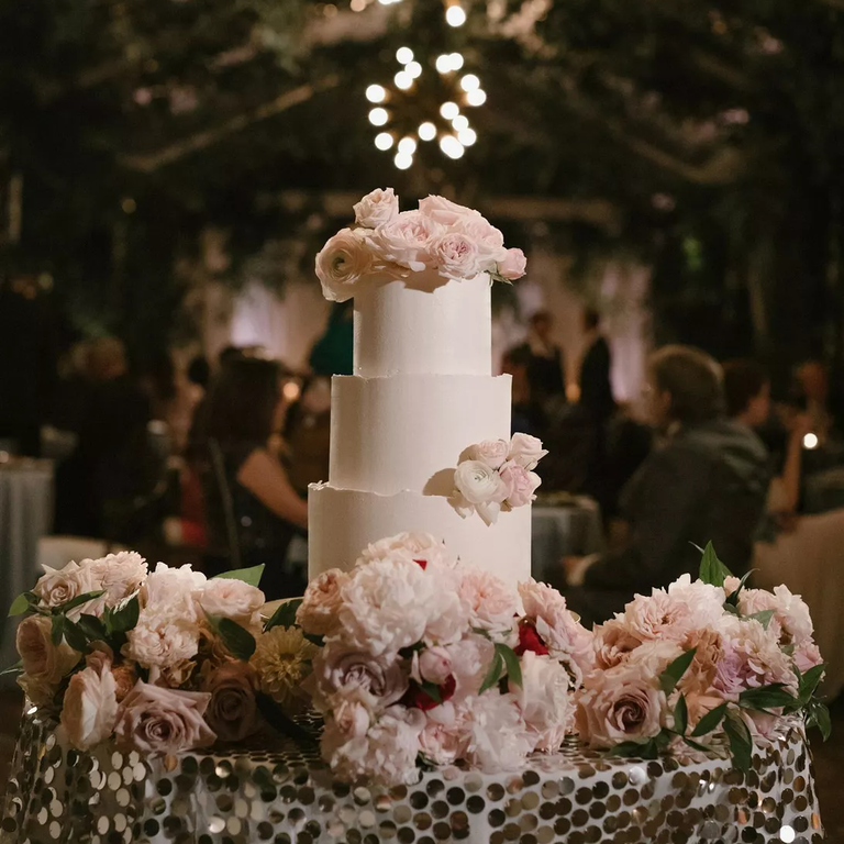 Tiered white wedding cake with white flowers