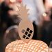 A gold lasercut pineapple topped one of Kelly and Adam's 16 wedding cakes; there was one for each table.