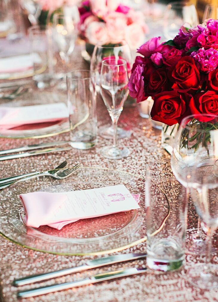Clear charger plates with a delicate gold rim highlighted the shimmery blush linens on the reception tables. The mix of red and pink flowers echoed those of her bridesmaid outfits.