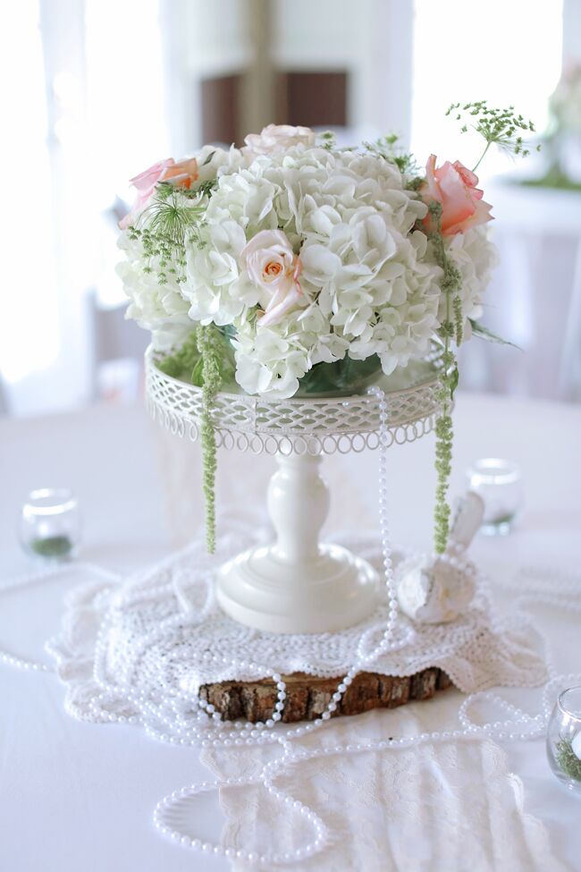 “My mother and I own an event and floral design company, Southern Magnolias, so we designed all the decor and all the floral work,” Linsie says. She incorporated peonies, garden roses, spray roses, ranunculus, Queen Anne’s lace and green amaranthus with pearls, moss and wood to create the vintage-inspired centerpieces.