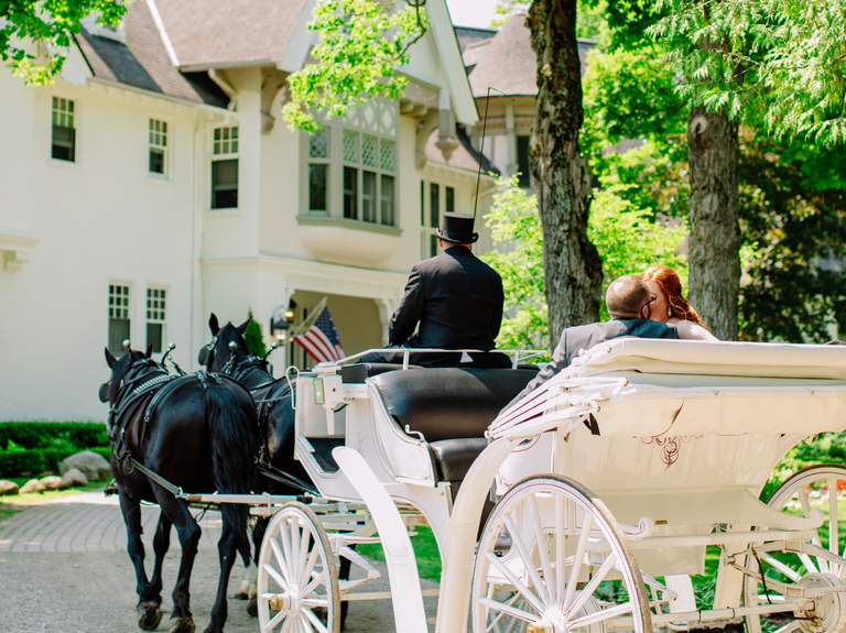 A happy couple enjoys a ride in an antique horse-and-carriage at the Inn at Stonecliffe Mansion & Suites.