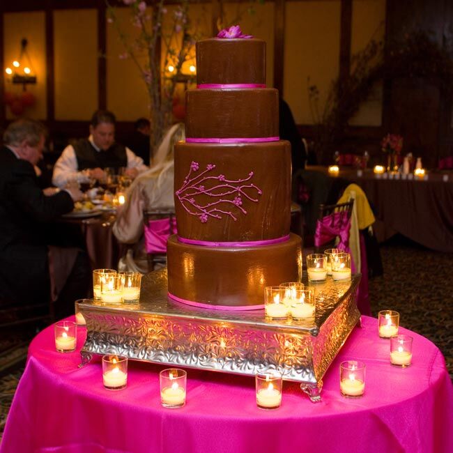 The four-tiered confection featured vanilla chiffon cake with vanilla bean filling and fresh raspberry-chocolate buttercream icing. It was decorated with tiny, baby pink ribbon around the bottom of each tier and the couple’s signature, cherry blossom design.