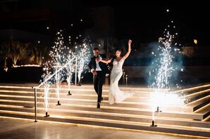 Groom in Navy Tuxedo and Bride in Plunging Neckline Wedding Dress Enter Reception Amid Sparklers