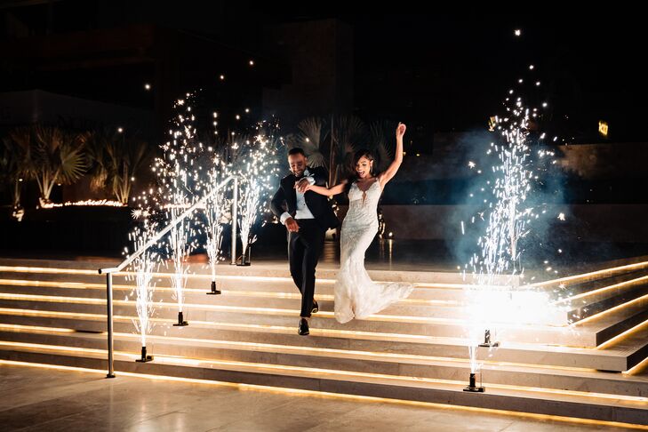 Groom in Navy Tuxedo and Bride in Plunging Neckline Wedding Dress Enter Reception Amid Sparklers