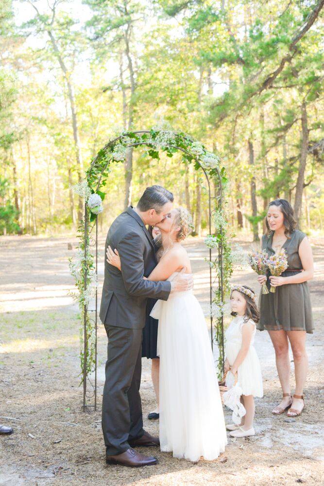 Stephanie and Michael added multiple DIY elements to their natural fete at Lakeside Clubhouse Wedding & Reception Facility in Medford, New Jersey. Their wedding arch was one of them. Michael decorated every metal detail with a garland of ivy and greenery, baby’s breath and white hydrangeas. Each detail highlighted the flowers in Stephanie’s updo as they shared their first kiss.
