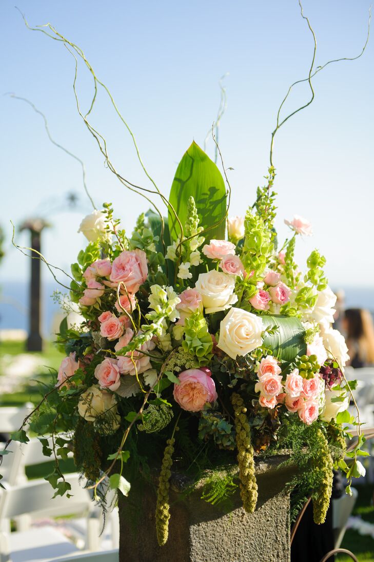 Lush arrangements of greens and blooms decorated the indoor-outdoor spaces at the venue throughout the day. Pink and white roses were arranged with bells of Ireland, stock, branches and leafy greens.
