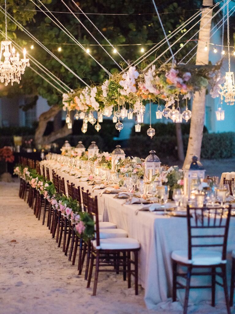 romantic hanging wedding centerpiece with pink roses, greenery and votive candles in glass orbs