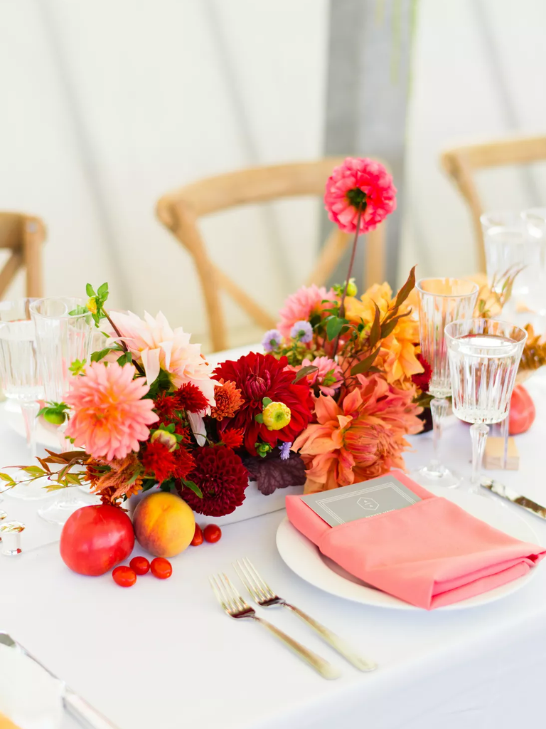 A cheerful table arrangement of red and pink dahlias.
