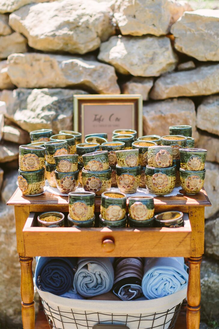 The wooden piece displayed crafty mugs given out as wedding favors on top, and blue blankets neatly rolled up at the bottom.