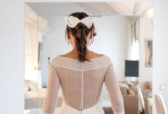 Bride wears a white bow in her hair. 