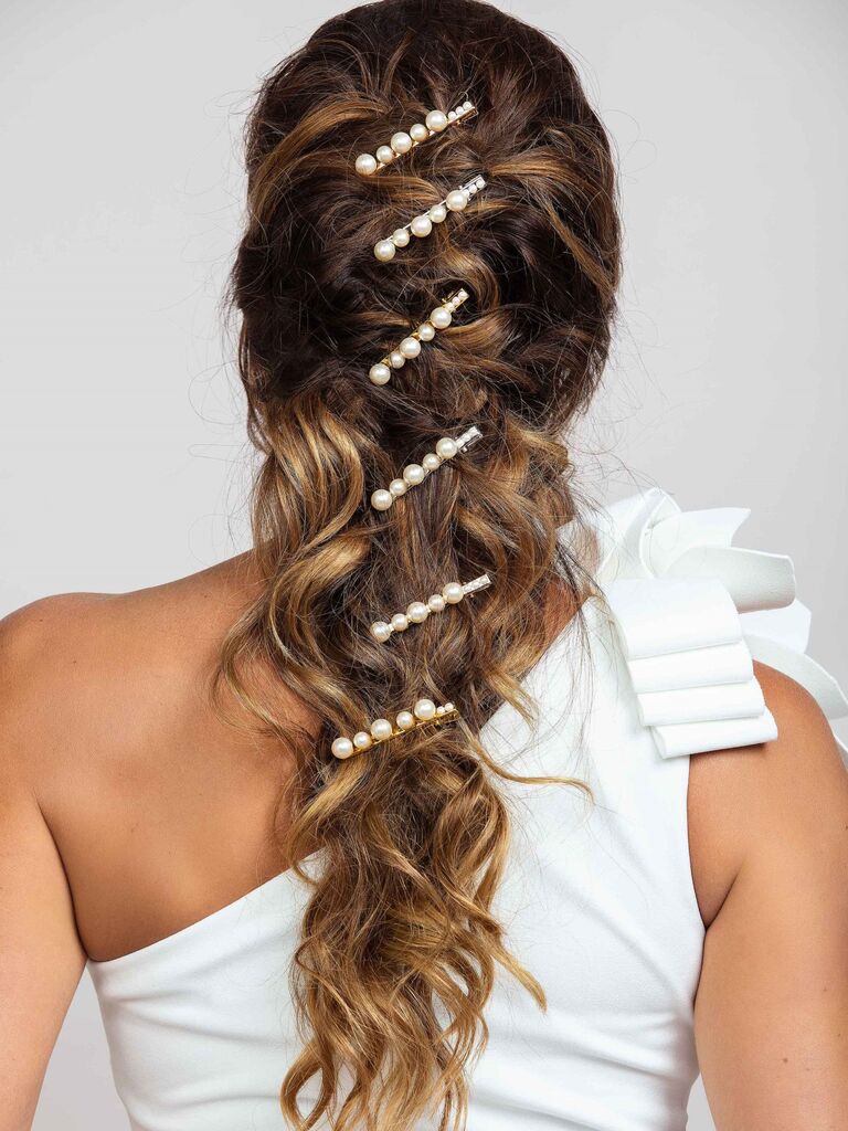 Model wears various pearl clips in her hair. 