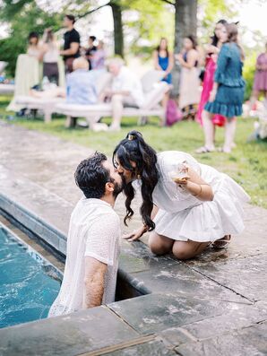 Bride Kissing Groom in Pool at Summer Rehearsal Dinner