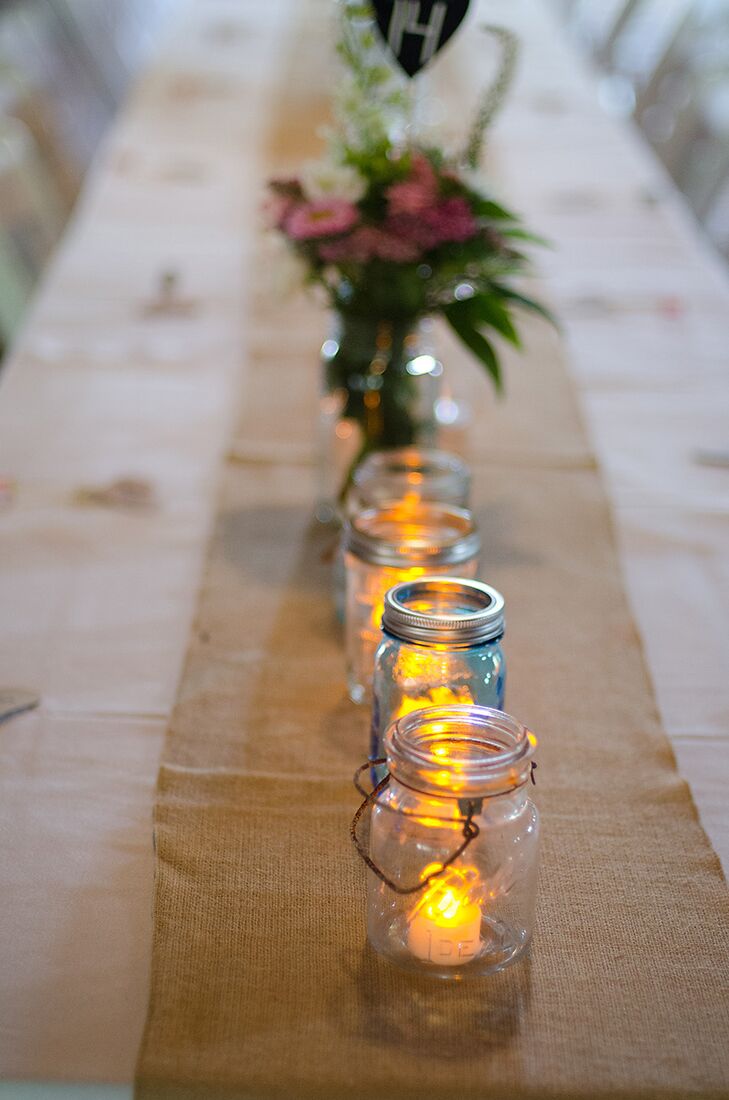 Keeping with the rustic style of the wedding, Mary and Sam's dining tables featured long, burlap table runners with mason jars filled with battery-powered candles.