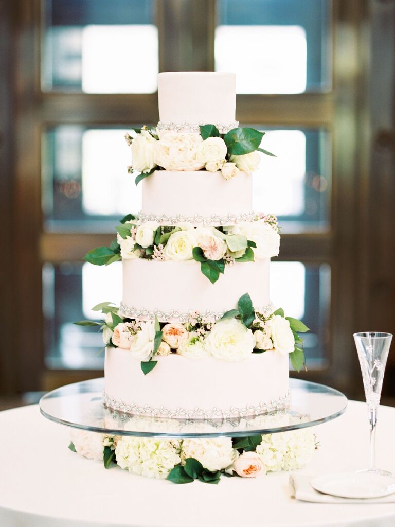 white four tier wedding cake with blush and ivory roses in between each tier